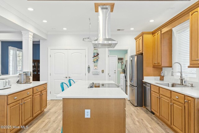 kitchen featuring a kitchen island, light wood-style flooring, island exhaust hood, stainless steel appliances, and a sink