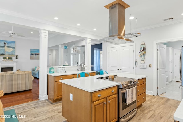 kitchen featuring island range hood, a kitchen island, decorative columns, and stainless steel electric range oven