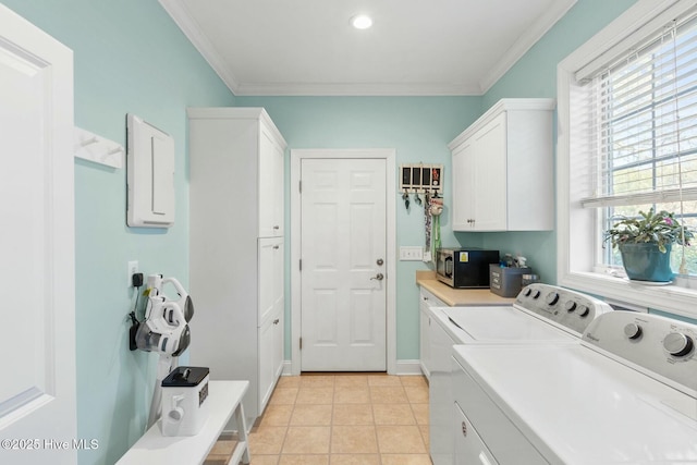 laundry area featuring baseboards, washing machine and dryer, ornamental molding, light tile patterned floors, and cabinet space