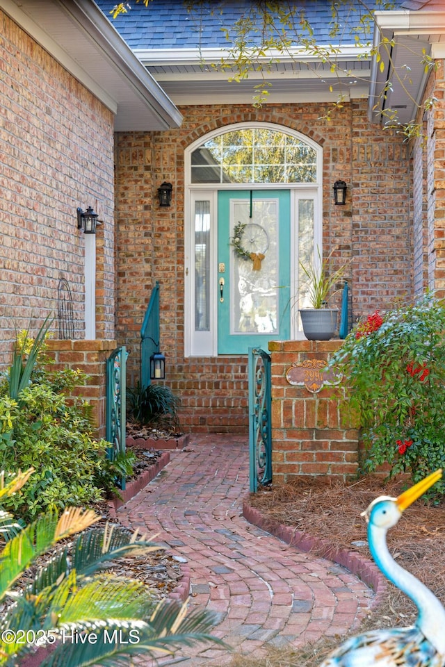 entrance to property featuring brick siding