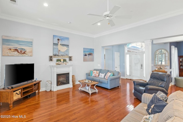 living room with hardwood / wood-style floors, ornamental molding, decorative columns, and ceiling fan