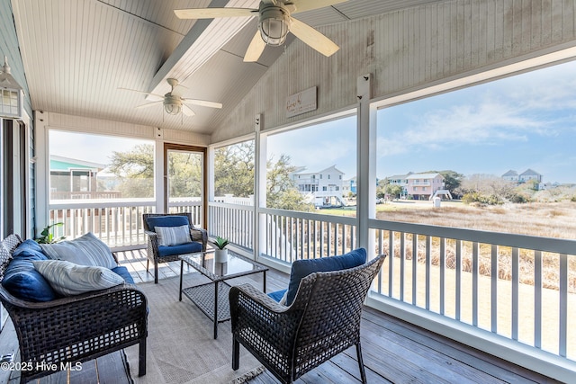 sunroom featuring a residential view, ceiling fan, and lofted ceiling