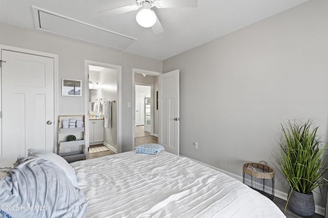 bedroom with ensuite bathroom, a ceiling fan, baseboards, light wood finished floors, and attic access