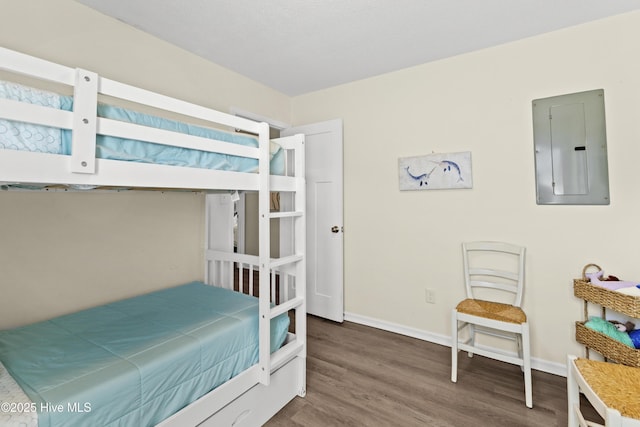 bedroom with dark wood finished floors, electric panel, and baseboards