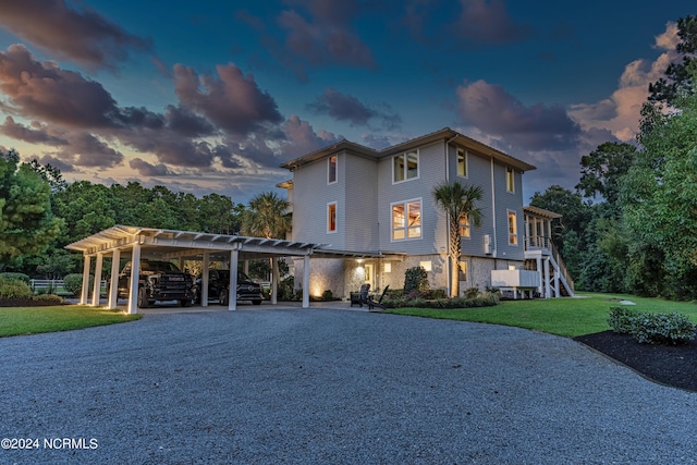 view of front of property with a carport and a lawn