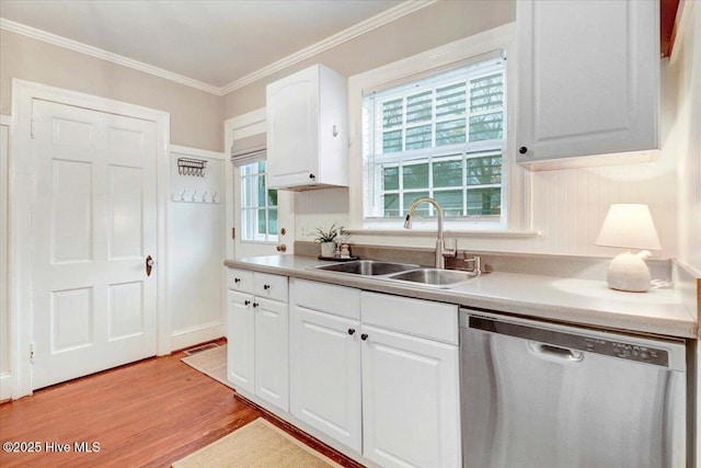 kitchen with sink, dishwasher, white cabinetry, ornamental molding, and light hardwood / wood-style floors