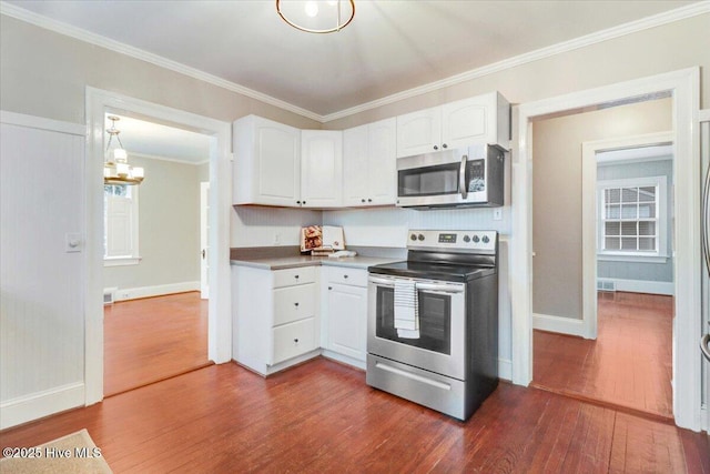 kitchen with decorative light fixtures, dark wood-type flooring, white cabinets, and appliances with stainless steel finishes