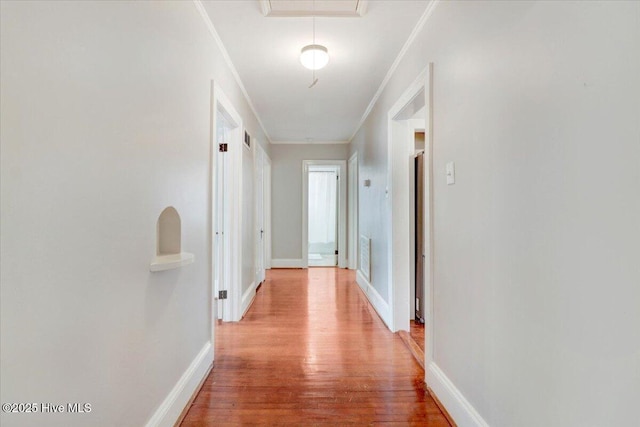 hallway featuring ornamental molding and light wood-type flooring