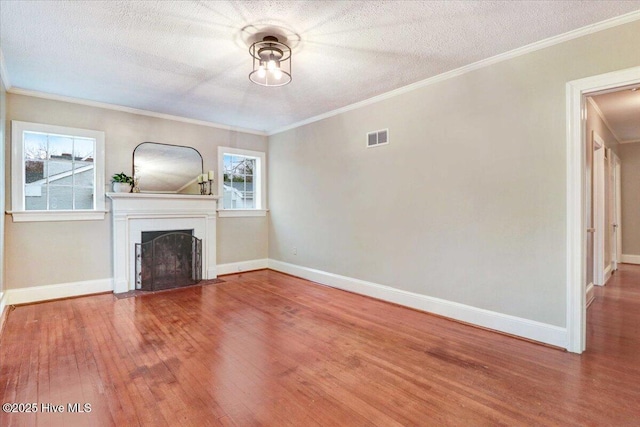 unfurnished living room with ornamental molding, wood-type flooring, and a textured ceiling