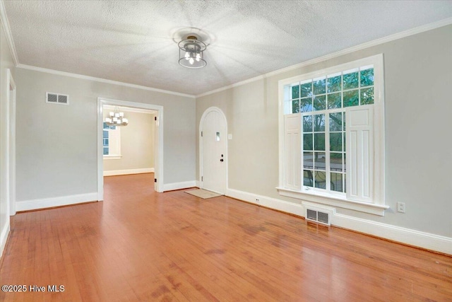 foyer entrance with ornamental molding, wood-type flooring, and a wealth of natural light