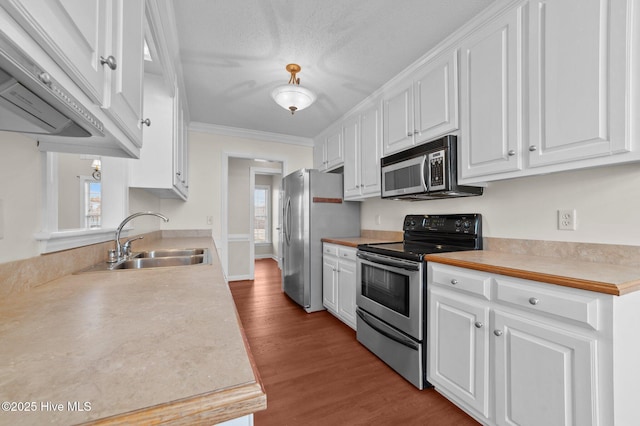 kitchen with sink, crown molding, light hardwood / wood-style flooring, appliances with stainless steel finishes, and white cabinets