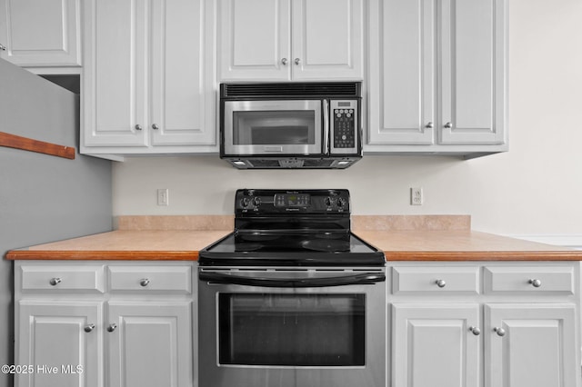 kitchen featuring white cabinetry and electric range oven