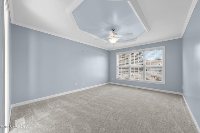 spare room with ceiling fan, light colored carpet, ornamental molding, and a tray ceiling