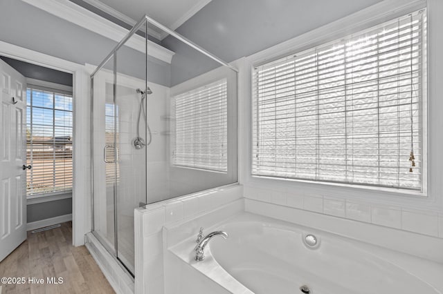 bathroom with hardwood / wood-style flooring, ornamental molding, and shower with separate bathtub