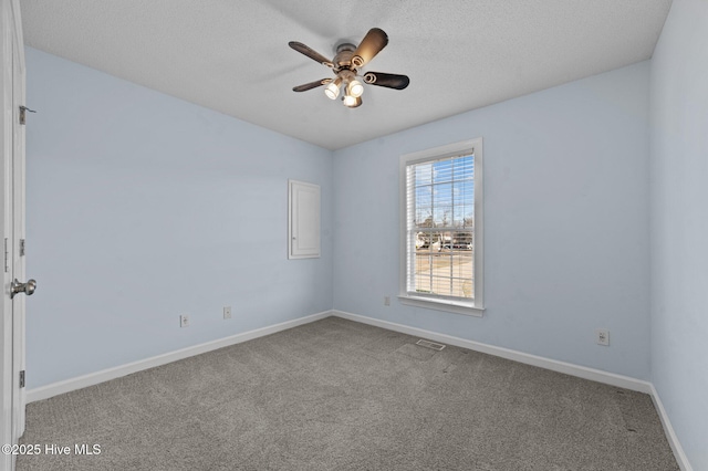 carpeted empty room with ceiling fan and a textured ceiling