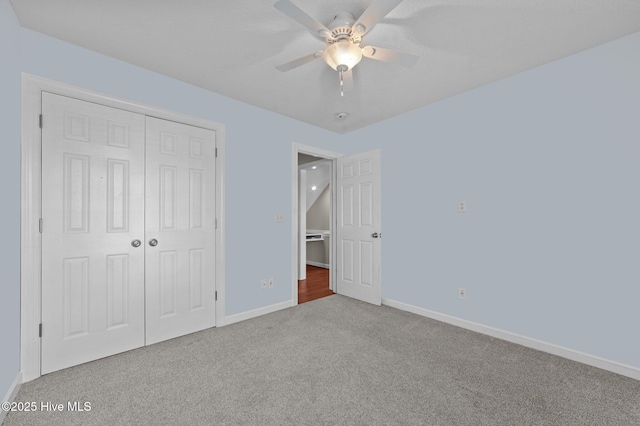 unfurnished bedroom featuring carpet, ceiling fan, and a closet