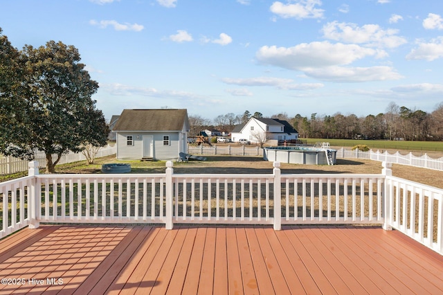 wooden terrace featuring a yard, a covered pool, and a shed