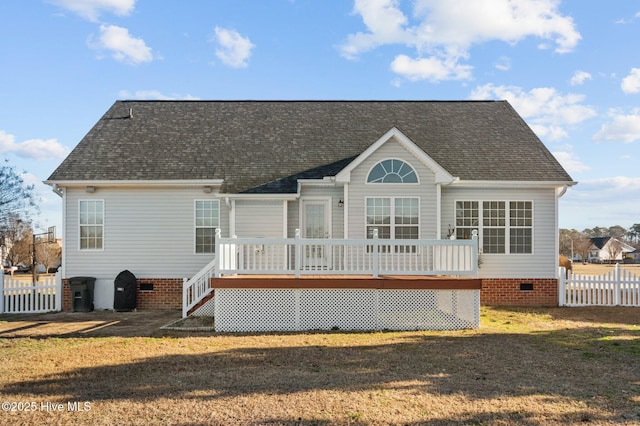 rear view of property featuring a wooden deck and a lawn