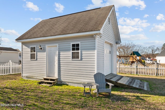 back of property featuring an outbuilding, a lawn, and a playground