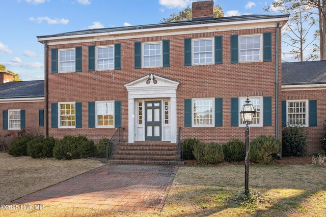 colonial inspired home featuring a front yard