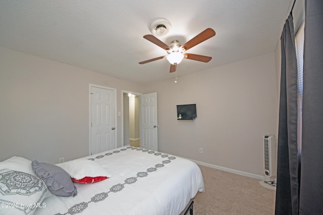 carpeted bedroom with ceiling fan and a textured ceiling