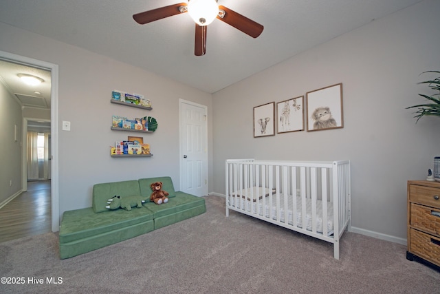 bedroom featuring a crib, carpet flooring, and ceiling fan