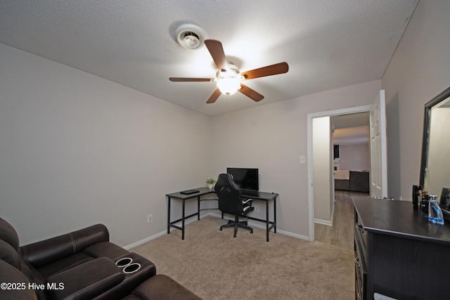 carpeted office space featuring ceiling fan and a textured ceiling