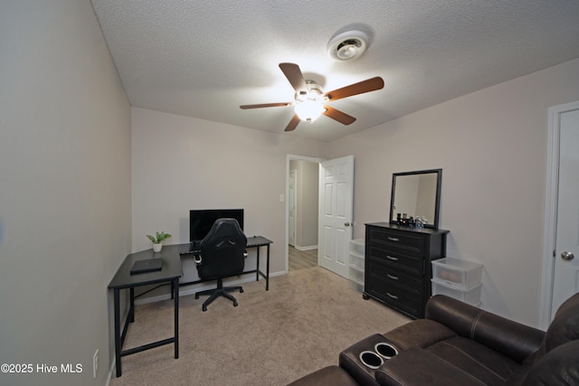 home office featuring ceiling fan, light colored carpet, and a textured ceiling