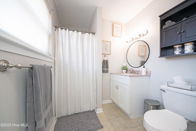 bathroom with tile patterned flooring, vanity, walk in shower, and toilet