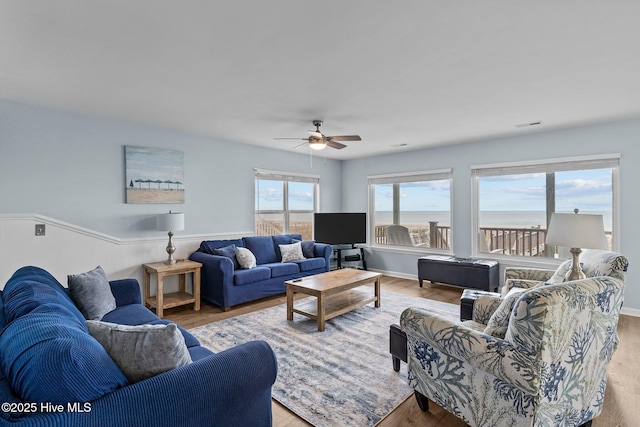 living area featuring visible vents, a ceiling fan, and light wood-style floors