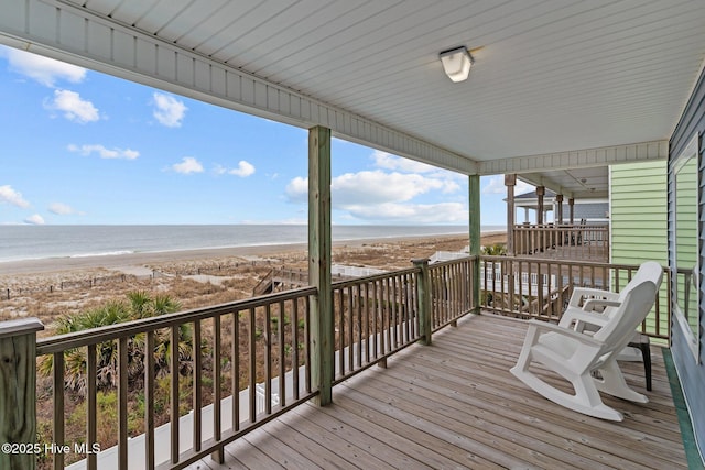 deck with a water view and a view of the beach