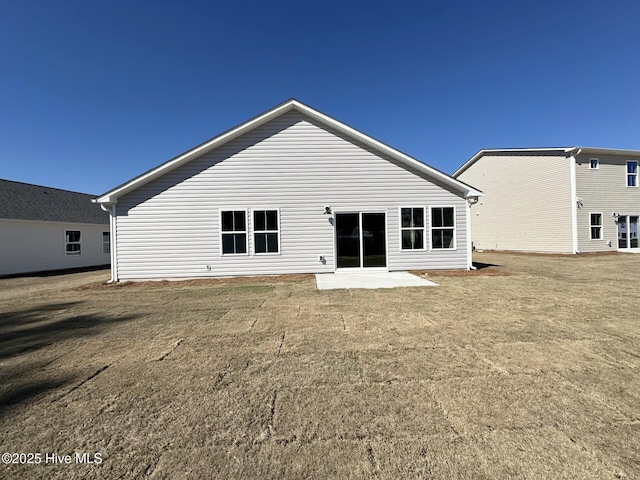 back of property featuring a patio and a lawn