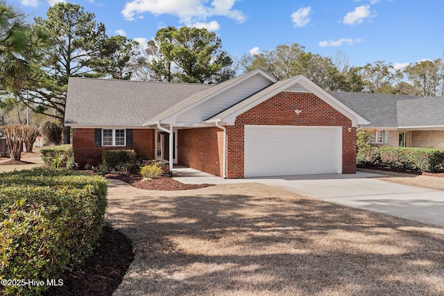 single story home with brick siding, a garage, driveway, and a shingled roof