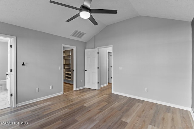 6148 Sugar Pine Dr, Wilmington, NC 28412 - unfurnished bedroom with a spacious closet, vaulted ceiling, wood finished floors, a closet, and ensuite bathroom