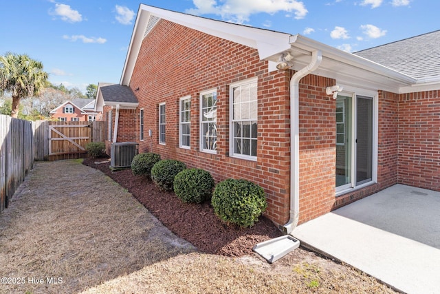 6148 Sugar Pine Dr, Wilmington, NC 28412 - view of side of property featuring brick siding, central AC unit, a gate, and a patio area