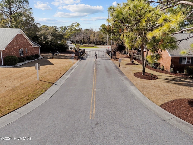 6148 Sugar Pine Dr, Wilmington, NC 28412 - view of asphalt road featuring a gate and curbs