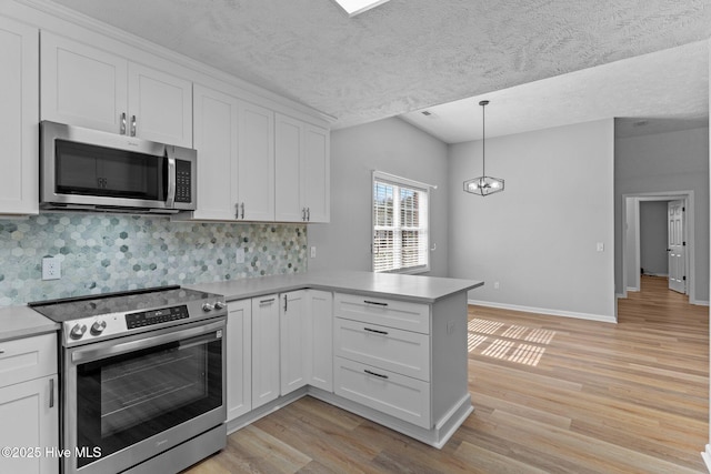 6148 Sugar Pine Dr, Wilmington, NC 28412 - kitchen with stainless steel appliances, a peninsula, light wood-style floors, white cabinetry, and light countertops