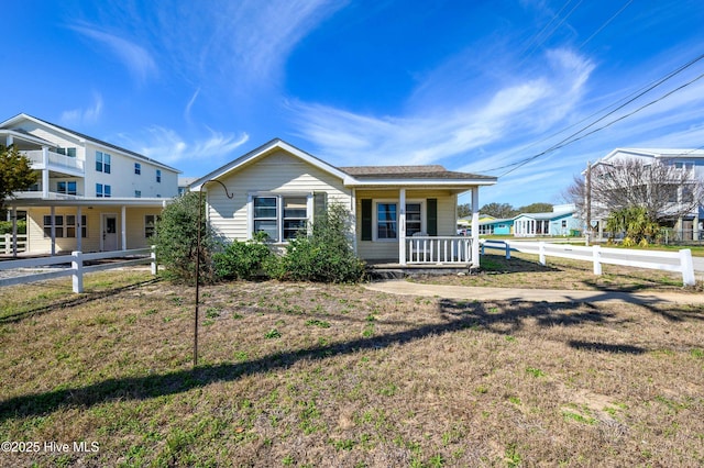 view of front of property featuring a front yard, a porch, and fence