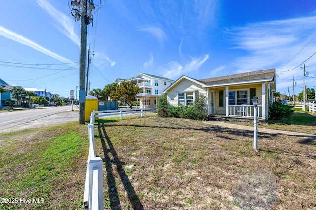 view of front of home featuring covered porch and fence