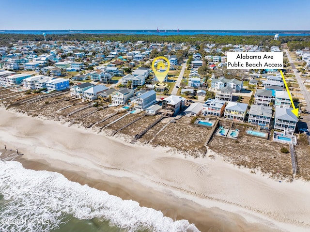 birds eye view of property featuring a beach view and a water view