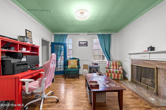 office area with ornamental molding, a fireplace, and wood finished floors