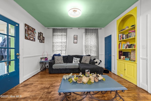 living room featuring built in features and wood finished floors