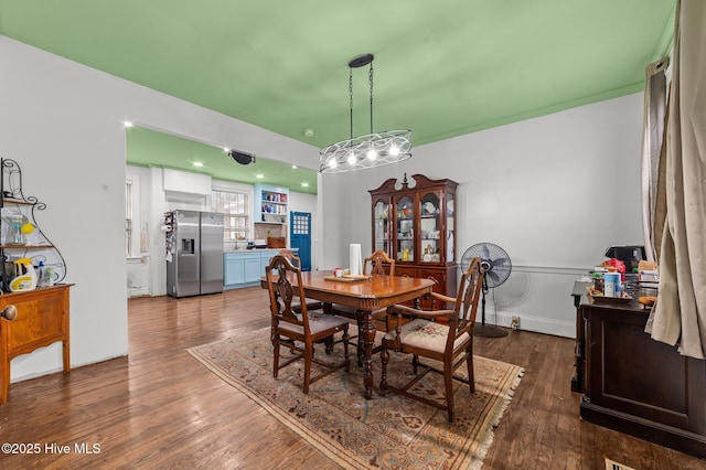 dining room featuring a wainscoted wall and dark wood-type flooring