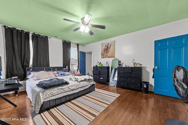 bedroom with visible vents, dark wood finished floors, and ceiling fan