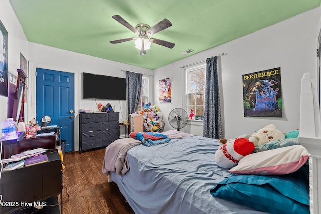 bedroom featuring dark wood-type flooring, visible vents, and a ceiling fan