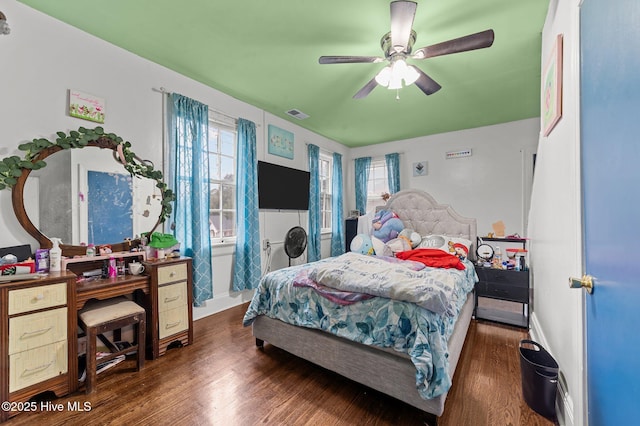 bedroom with dark wood-style floors, visible vents, and ceiling fan