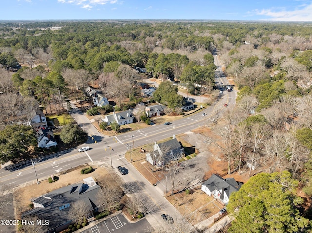 drone / aerial view featuring a residential view and a wooded view