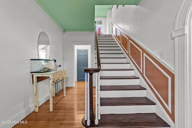 staircase with baseboards and wood finished floors