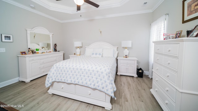 bedroom featuring a raised ceiling, crown molding, ceiling fan, and light hardwood / wood-style flooring