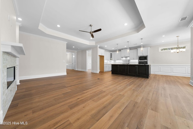 unfurnished dining area with crown molding, wood finished floors, an inviting chandelier, and visible vents